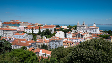 Fototapeta na wymiar Old Lisbon. A panoramic view over the rooftops of the Old Town of the Portuguese capital of Lisbon on a bright and sunny summers day.