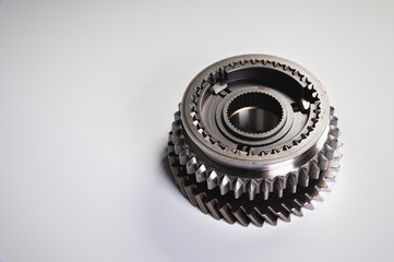 New parts on a gray background. Gears of gear shifting torque transmission. Conceptually mechanical background. Shiny gear box gear teeth