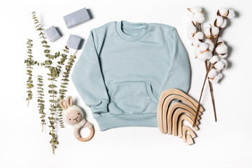 Background of children's products. Concept of clothing for babies. mint t-shirt, a toy, a rattle
