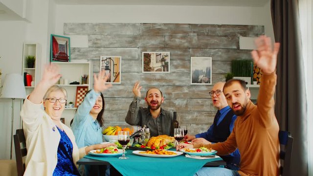 POV Shot Of Family At Dinner Having A Video Call With Friends.