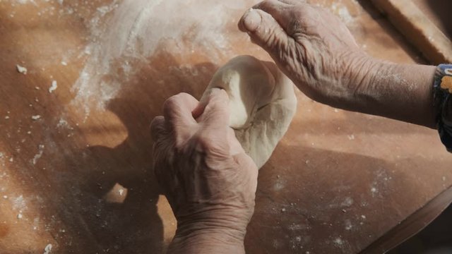 Grandmother in the kitchen is preparing a traditional home-made dish