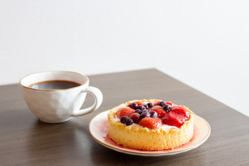 Strawberry cake and a cup of coffee on the table. Selective focus