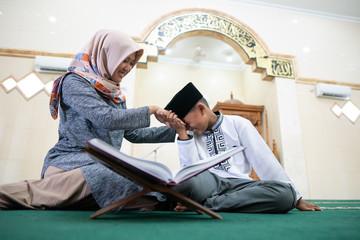 muslim kid pay respect to his teacher before studying in the mosque