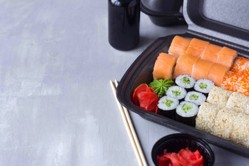 sushi delivery, home delivery in plastic and paper packaging, contactless delivery during the coronavirus epidemic, place for text