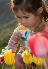 little child playing with flowers