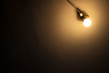 Old light bulb on the wall, glowing lamp