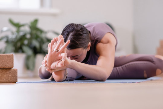 Calm spiritualized young woman yoga instructor meditates in the pose of madha mudra. Concept of the disclosure of energy channels and home yoga sessions. Advertising space