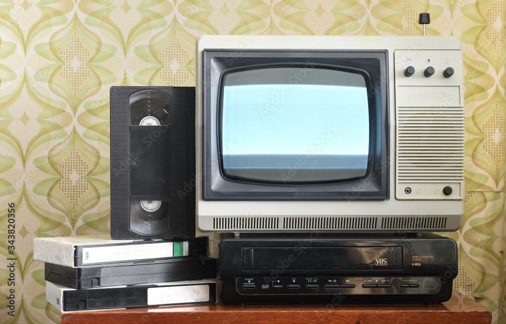 Wall mural Old silver-colored TV with a VCR on the background of wallpaper.Screen noise.