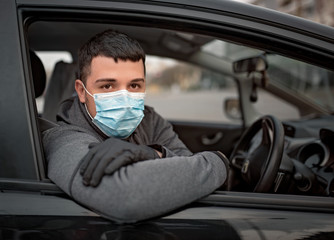 Man in the medical mask and rubber gloves for protect himself from bacteria and virus while driving a car. masked