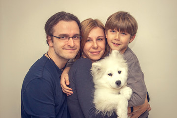 Happy family with dog posing for photo inside the house.