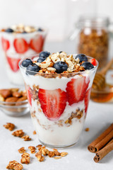 Granola Parfait with greek yogurt, oat cereal, fresh berries, honey in glass jar