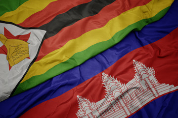 waving colorful flag of cambodia and national flag of zimbabwe.