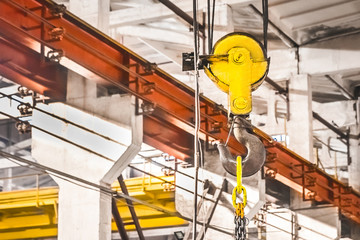 Overhead crane lifting hook on the background of an industrial enterprise, close-up	