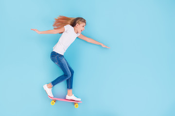 Top above high angle view full length photo of energetic excited kid girl ride skateboard empty space enjoy fun lay isolated over blue color background © deagreez