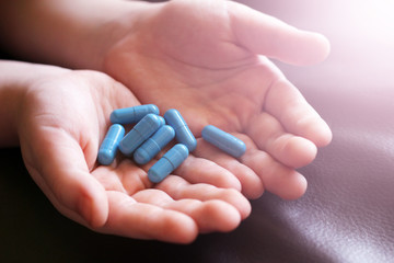 Blue capsules in children's hands