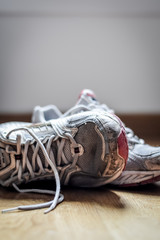 Old dirty sneakers close up, selective focus, desaturated colors.
