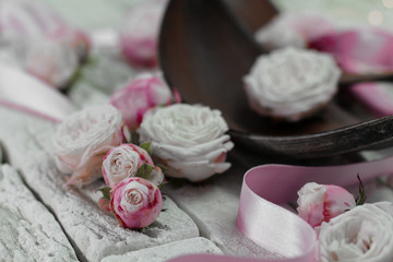 Obraz na płótnie Canvas Close-up pink roses with satin ribbon brown bark on gray bricks background