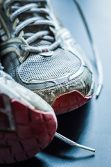 Old dirty sneakers close up, selective focus, desaturated colors.
