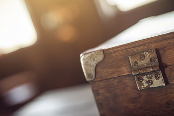 Details. A corner of the vintage wooden travelling suitcase. Shallow DOF. Strong backlight