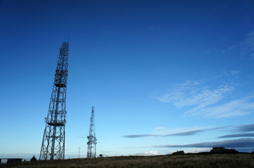 Silhouettes of antennas against the sunset sky.