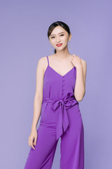 Portrait of beautiful young Asian woman over violet background.