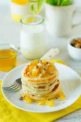 Homemade rustic pancakes stack with baked apples and walnuts