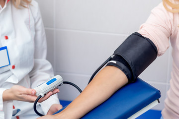 Nurse hand is measuring the pressure on arm in the hospital.