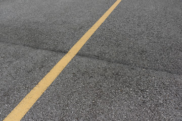 Fototapeta premium Yellow paint line on old asphalt road