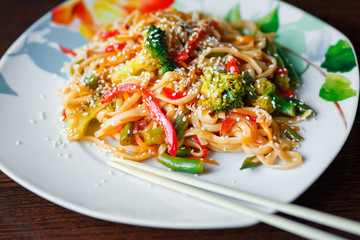 Thick wheat noodles with broccoli on ceramic plate.