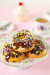 Homemade mini bundt cake covered with chocolate sauce and colorful sprinkles