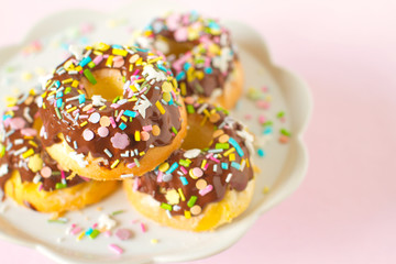 Homemade mini bundt cake covered with chocolate sauce and colorful sprinkles
