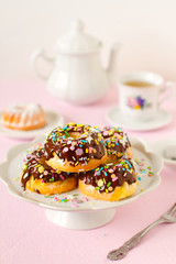 Homemade mini bundt cake covered with chocolate sauce and colorful sprinkles