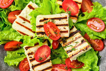 Macro photo of salad with grilled halloumi cheese, tomato and wine sauce