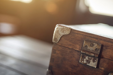 Details. A corner of the vintage wooden travelling suitcase. Shallow DOF. Strong backlight