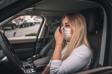 girl in a medical mask. beautiful blonde driving an expensive car. coronavirus, disease, infection, quarantine, medical mask, covid-19