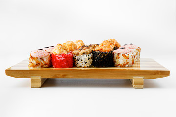 Maki Sushi Rolls set on wooden bamboo board. Japanese traditional Cuisine. White background.