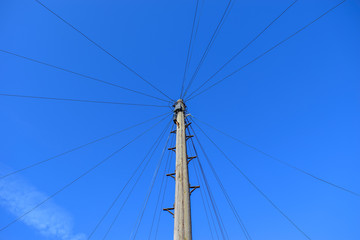 Telephone pole and wires against clear blue sky, London, UK