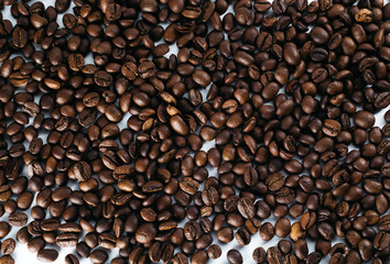 Coffee beans laid out on a white background with a basket