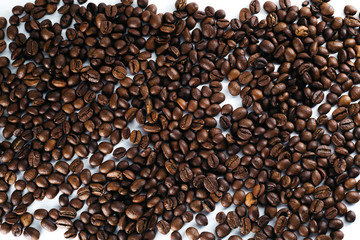Coffee beans laid out on a white background with a basket