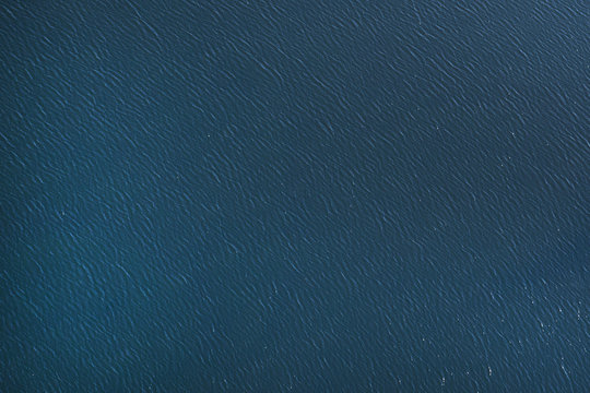 The surface of the blue sea, the lake. View from the plane
