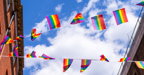Pride flags against blue sky in Chinatown, London, UK