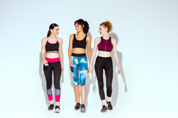 Fototapeta premium multicultural and sportive women walking on white