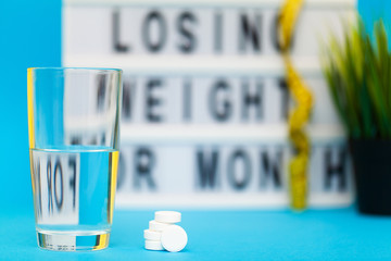 White weight loss pills on blue background