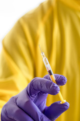 doctor with mask and safety suit, looking for information for vaccine.
