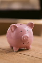 One pink ceramic piggy bank sitting on top of a wooden table