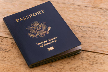 A blue American passport sitting on a wooden table