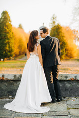 Sweet couple walking near vintage colorful, renaissance palaces for the wedding ceremony. Photo shoot near Medieval Castle