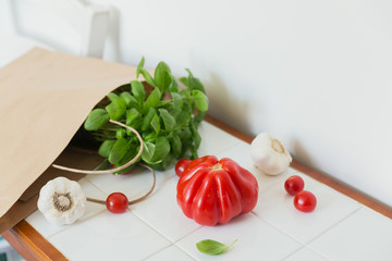 Healthy food in paper bag of groceries on white table with copy space.