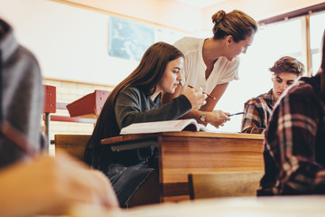 Professor helping students during a class at high school