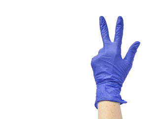 Hand in blue medical glove shows three gesture.